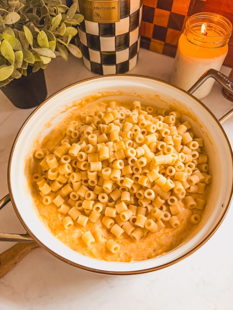 pasta added to mac and cheese in pot