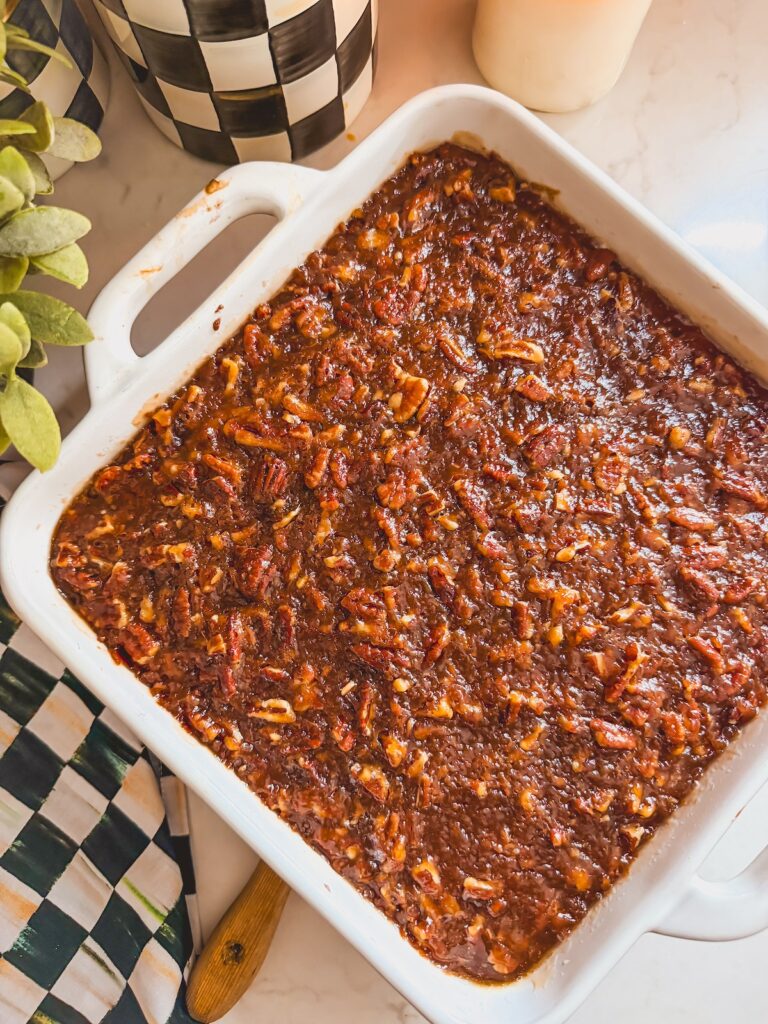 overhead shot of baked pecan pie brownies in white baking dish