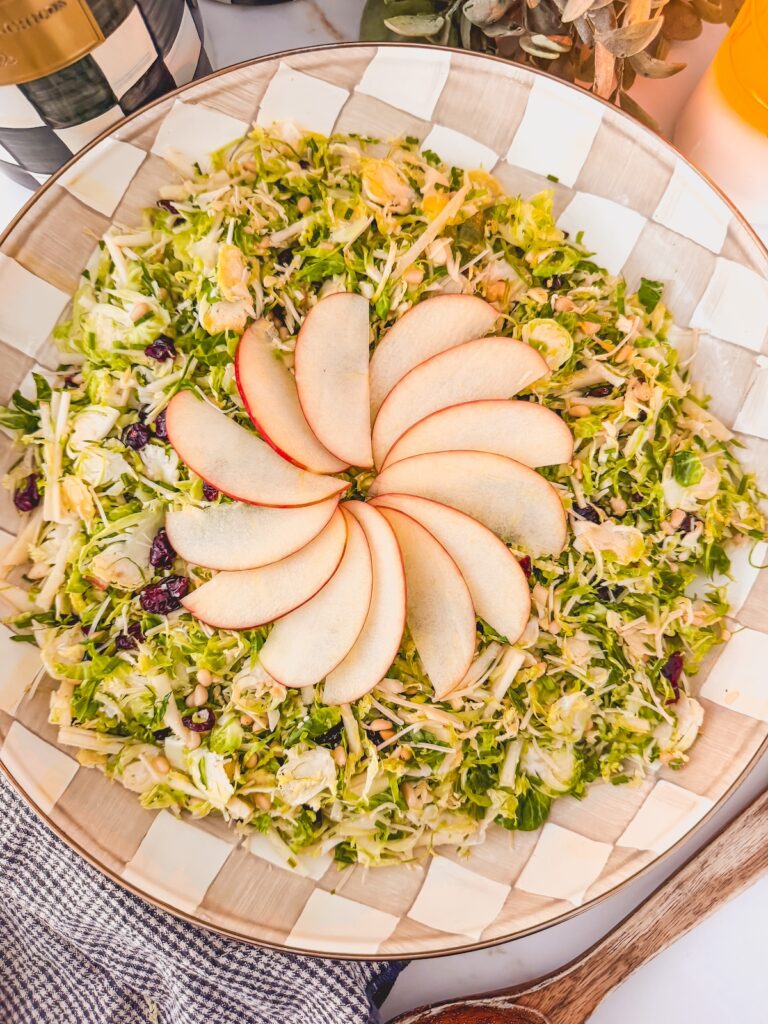 overhead shot of shaved brussels sprouts salad with fanned apple on top