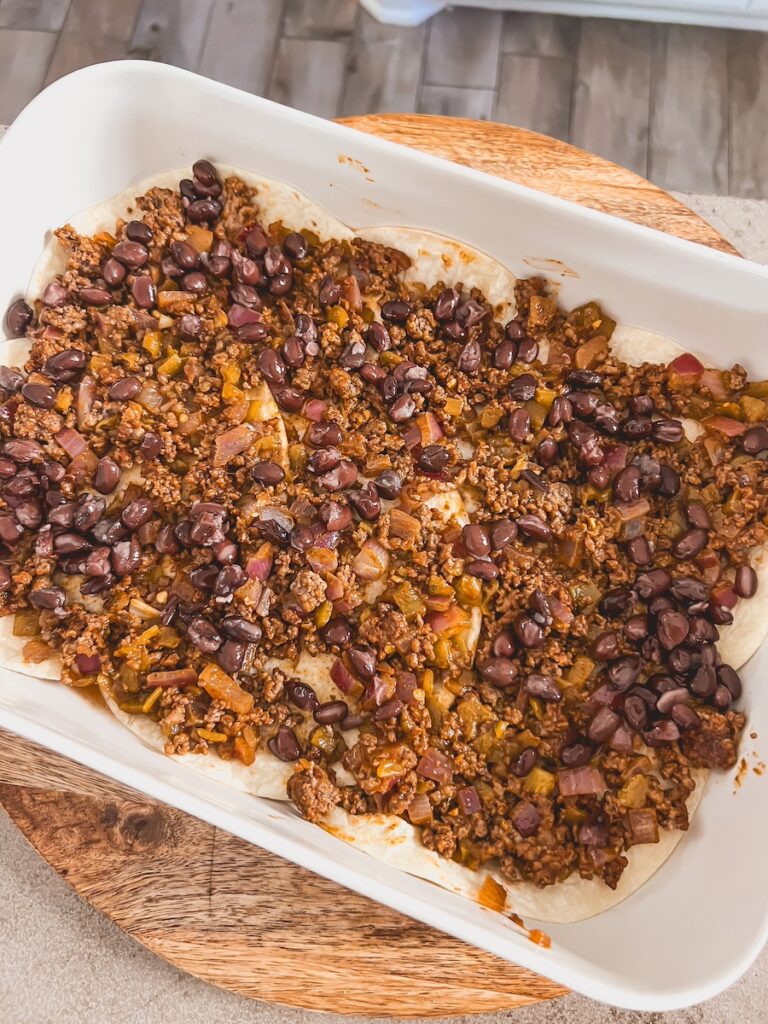 beef and beans layered on top of tortillas